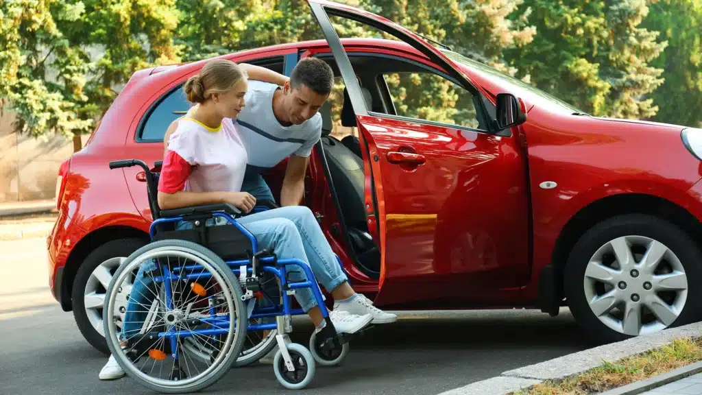 A female being assisted into her modified car - Driving Lessons For People With Physical Impairments and Disabilities on The Gold Coast